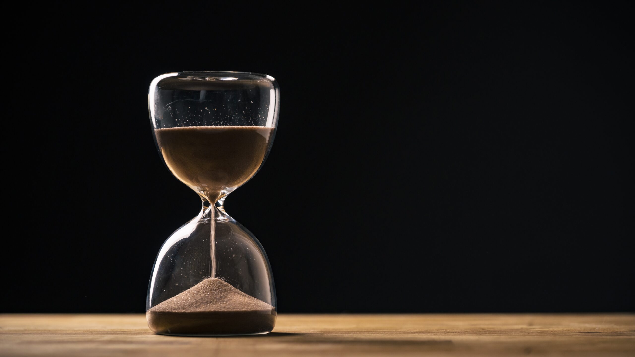 Sandglass,On,A,Black,Background,,Flowing,Golden,Sand,Grains,Falling